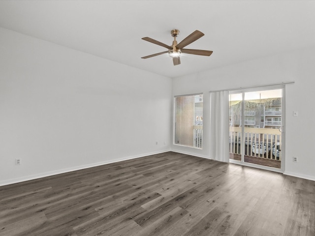 empty room with baseboards, dark wood-style floors, and a ceiling fan