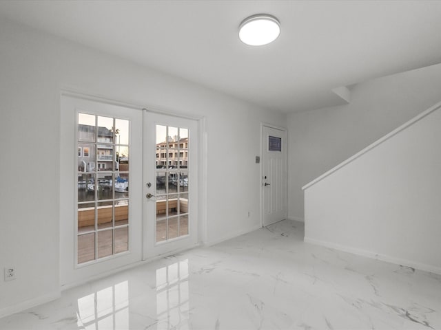 interior space with marble finish floor, french doors, and baseboards