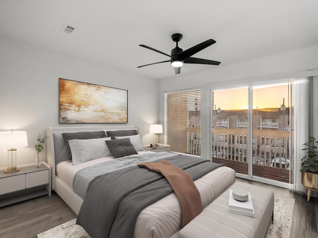 bedroom with visible vents, wood finished floors, ceiling fan, and access to outside