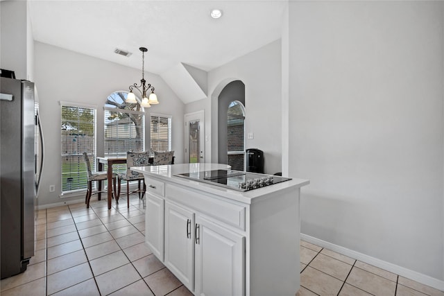 kitchen with visible vents, freestanding refrigerator, light tile patterned flooring, white cabinets, and black electric cooktop