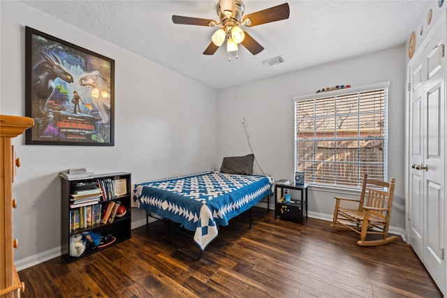 bedroom featuring visible vents, a textured ceiling, baseboards, and hardwood / wood-style flooring