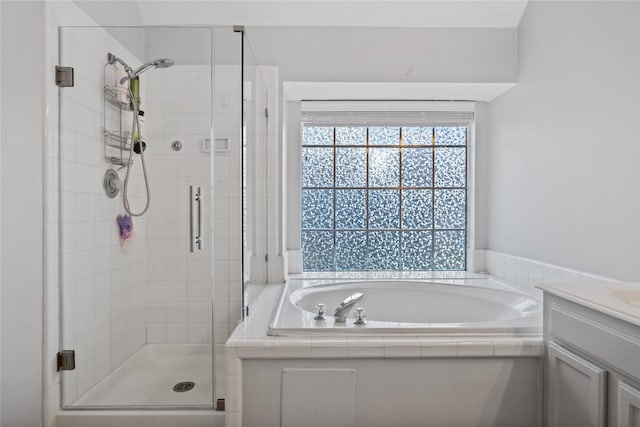 bathroom featuring vanity, a bath, and a shower stall