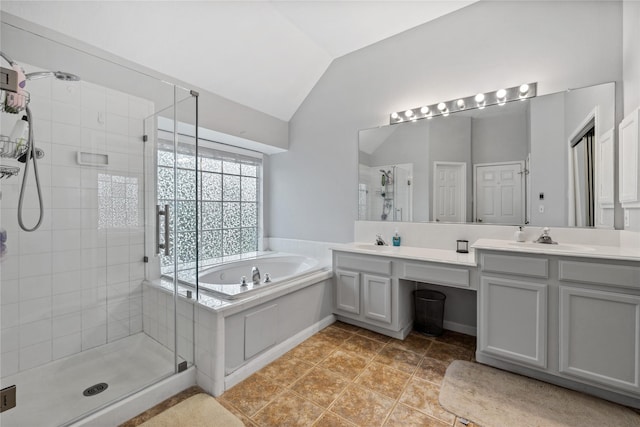 full bathroom with double vanity, a stall shower, a sink, vaulted ceiling, and a bath