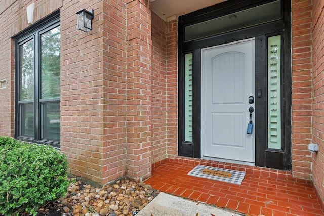 doorway to property featuring brick siding