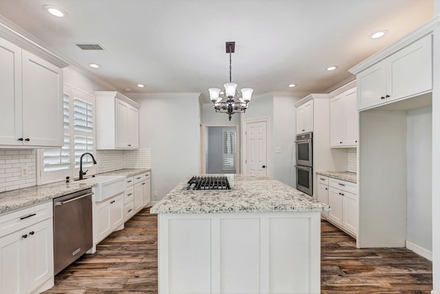 kitchen featuring appliances with stainless steel finishes, a kitchen island, a sink, and white cabinetry