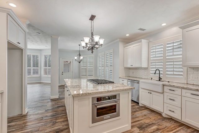 kitchen featuring dark wood finished floors, appliances with stainless steel finishes, decorative backsplash, and a sink