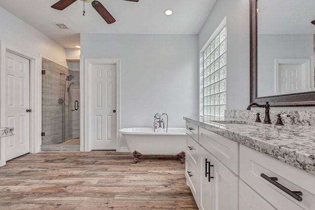 full bath with visible vents, a freestanding bath, a shower stall, vanity, and wood finished floors