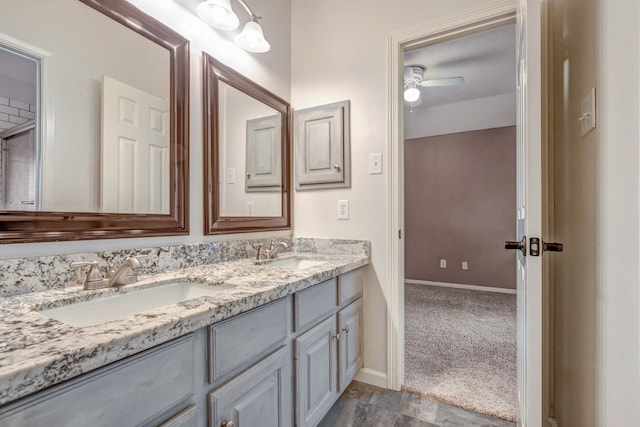 full bathroom featuring ceiling fan, a sink, baseboards, and double vanity