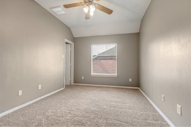 empty room with lofted ceiling, carpet floors, ceiling fan, and baseboards