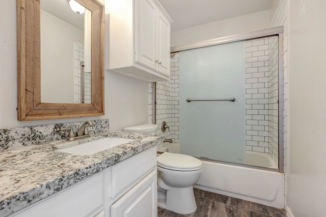 bathroom featuring combined bath / shower with glass door, vanity, toilet, and wood finished floors