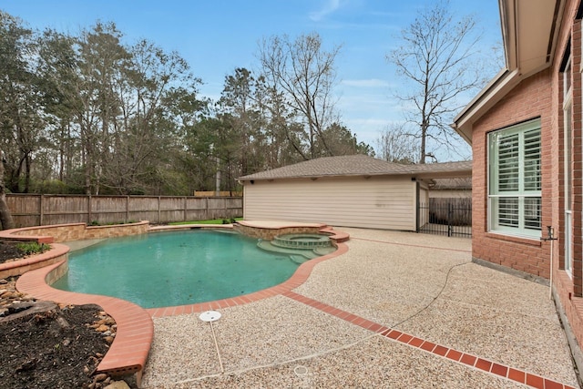 view of swimming pool featuring a patio area, a fenced backyard, and a pool with connected hot tub