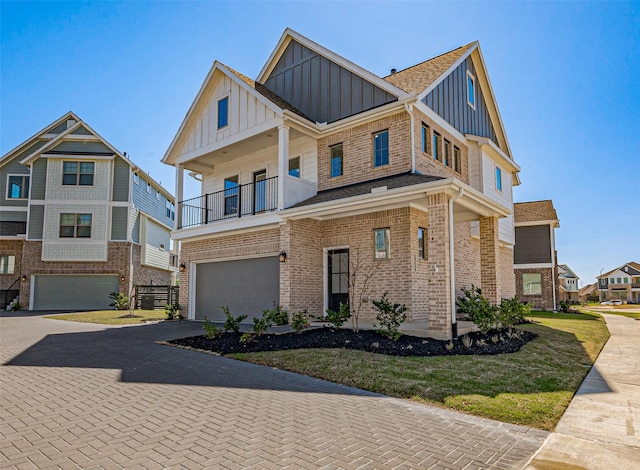 view of front of property with decorative driveway, brick siding, board and batten siding, and a balcony