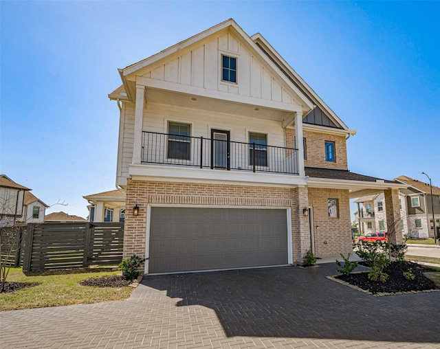 view of front of house with brick siding, board and batten siding, decorative driveway, and fence