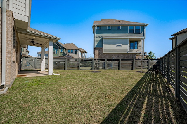 view of yard with ceiling fan and a fenced backyard