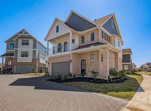 view of front facade with a balcony, a garage, board and batten siding, decorative driveway, and brick siding