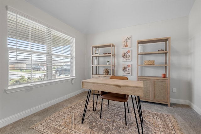 home office with light carpet, vaulted ceiling, and baseboards