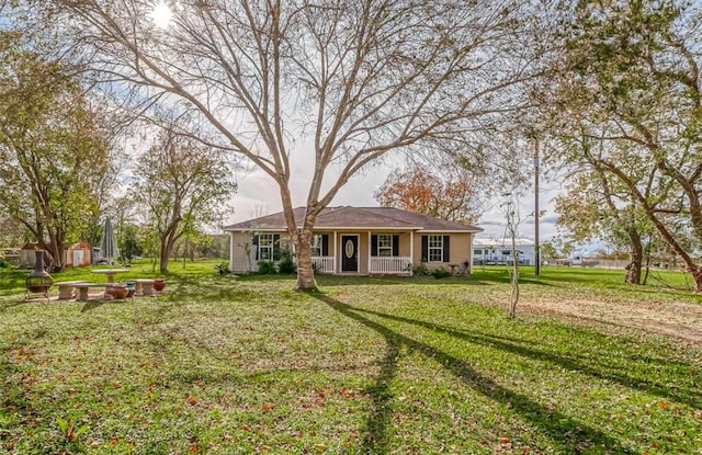 view of front of property featuring covered porch, an outdoor structure, and a front yard