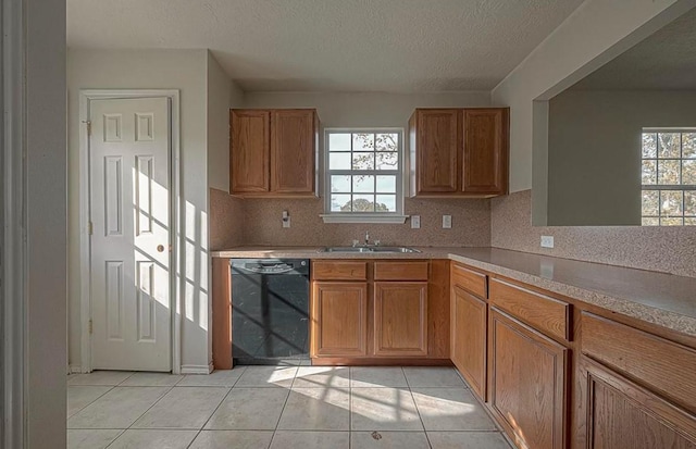 kitchen with black dishwasher, light tile patterned floors, plenty of natural light, and a sink