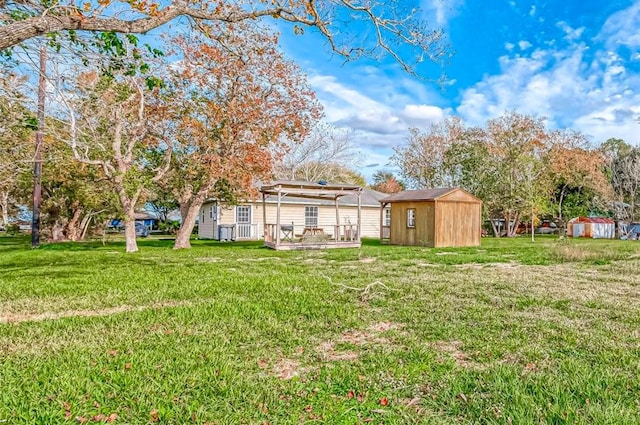 view of yard featuring an outbuilding, a deck, a storage shed, and a pergola
