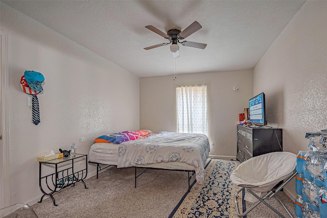 carpeted bedroom with a textured ceiling, a textured wall, ceiling fan, and baseboards