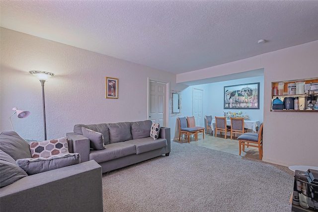 carpeted living room featuring a textured ceiling and a textured wall