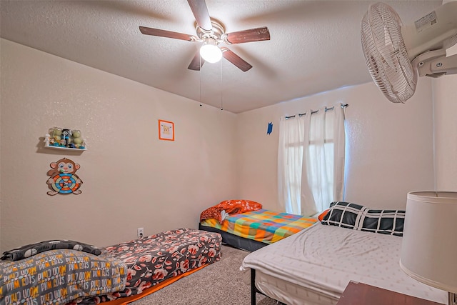 bedroom featuring a textured ceiling, carpet floors, and a ceiling fan