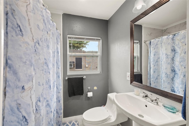 bathroom with ornamental molding, toilet, a sink, and a shower with shower curtain