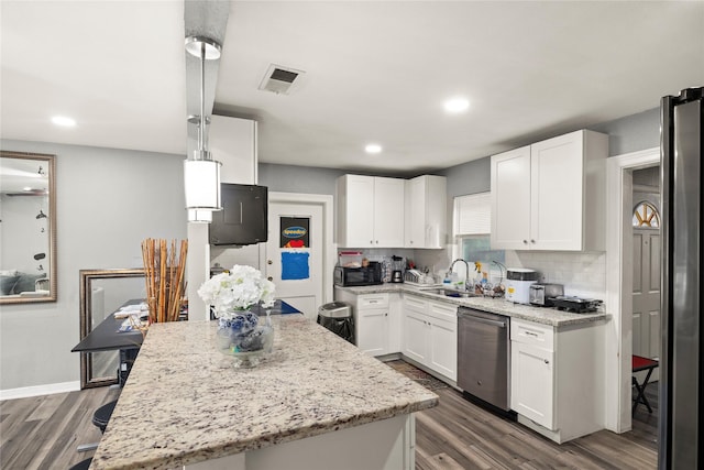 kitchen with stainless steel appliances, visible vents, a sink, and backsplash