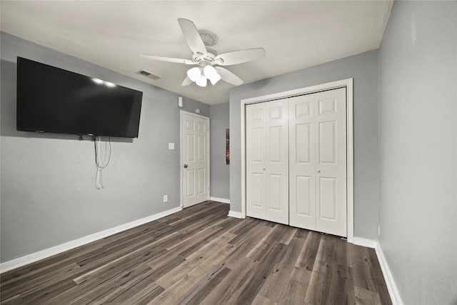 unfurnished bedroom featuring a closet, visible vents, dark wood finished floors, and baseboards