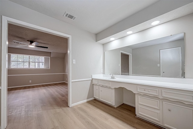 bathroom with ceiling fan, wood finished floors, vanity, visible vents, and baseboards