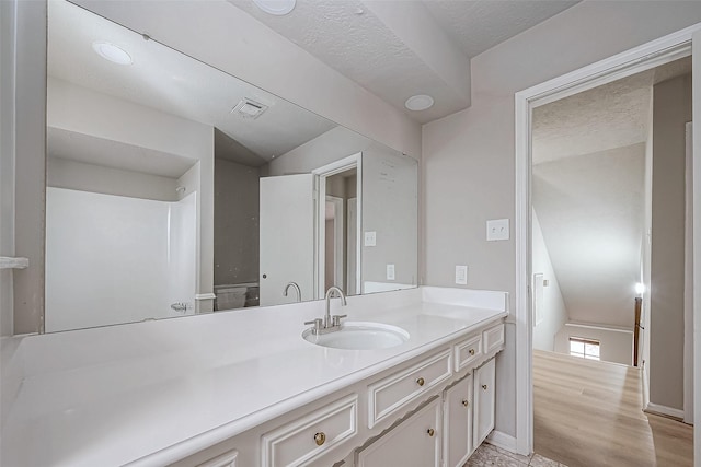 bathroom with baseboards, visible vents, wood finished floors, and vanity