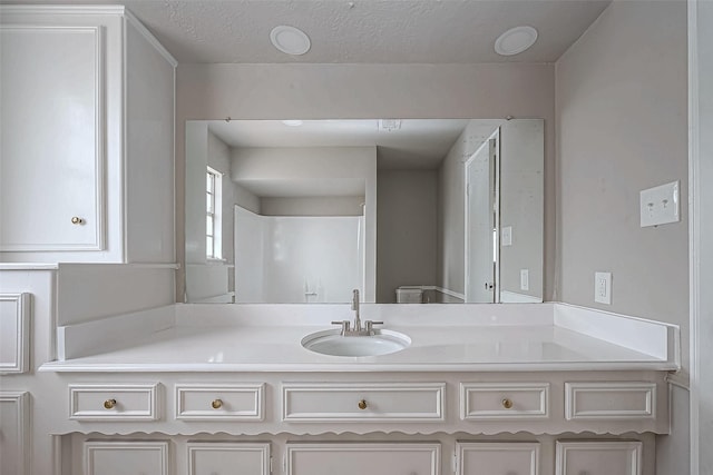 bathroom with a textured ceiling and vanity