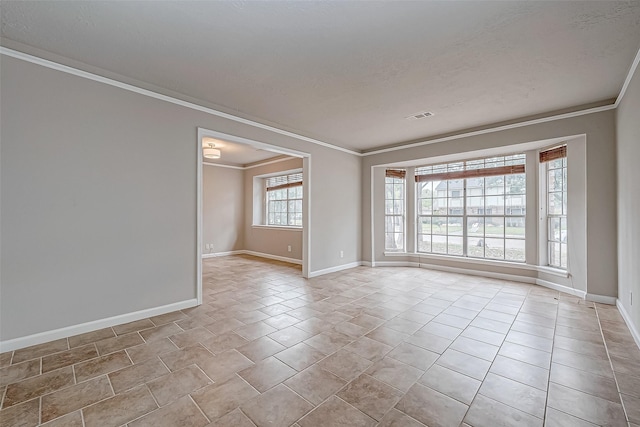 tiled spare room featuring baseboards, a textured ceiling, visible vents, and crown molding