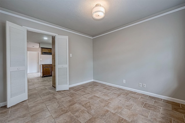 unfurnished room with baseboards and crown molding