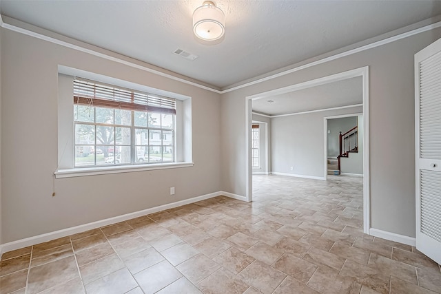 unfurnished room featuring visible vents, crown molding, baseboards, and stairs