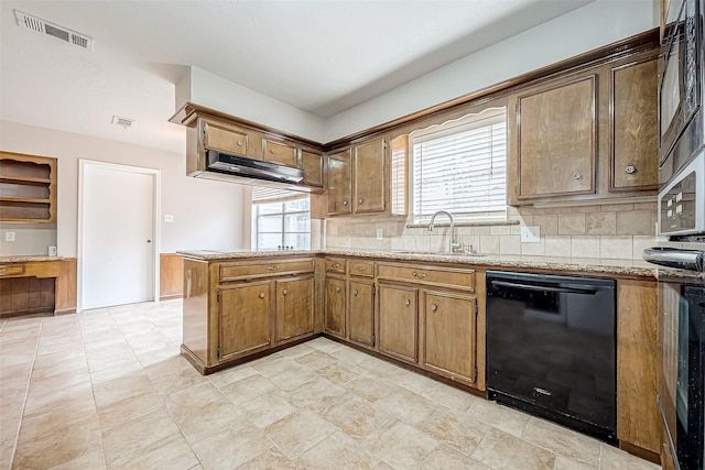 kitchen featuring a peninsula, a sink, visible vents, black appliances, and tasteful backsplash