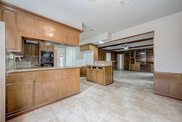 kitchen featuring black appliances, brown cabinetry, a sink, and visible vents