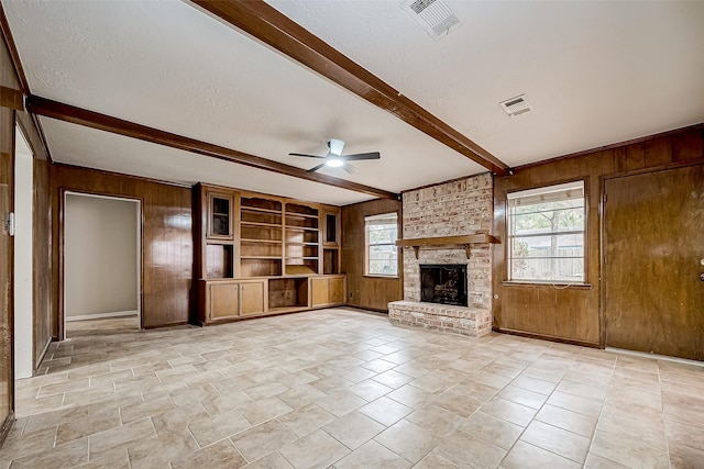 unfurnished living room with a wealth of natural light and wood walls