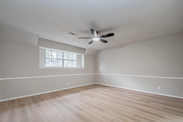 unfurnished room with ceiling fan, a textured ceiling, wood finished floors, visible vents, and baseboards