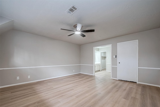 empty room with light wood finished floors, visible vents, a ceiling fan, a textured ceiling, and baseboards