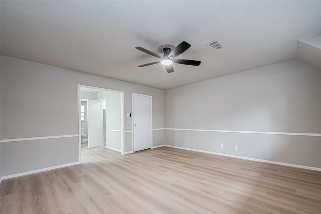 spare room with a ceiling fan, visible vents, light wood-style flooring, and baseboards