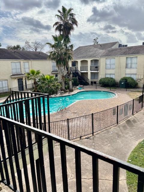 community pool featuring a patio area and fence