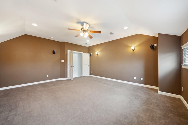 carpeted spare room with lofted ceiling, ceiling fan, visible vents, and baseboards