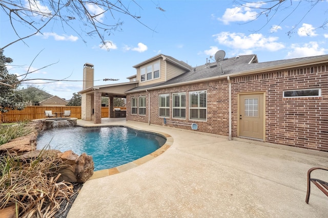 view of pool with a fenced backyard, a pool with connected hot tub, and a patio