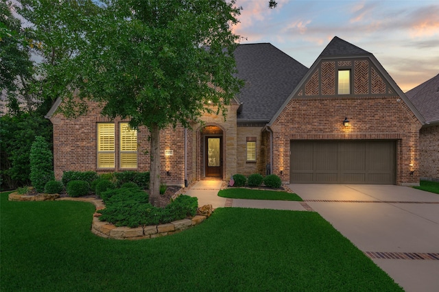 view of front of home with a front yard, concrete driveway, and brick siding