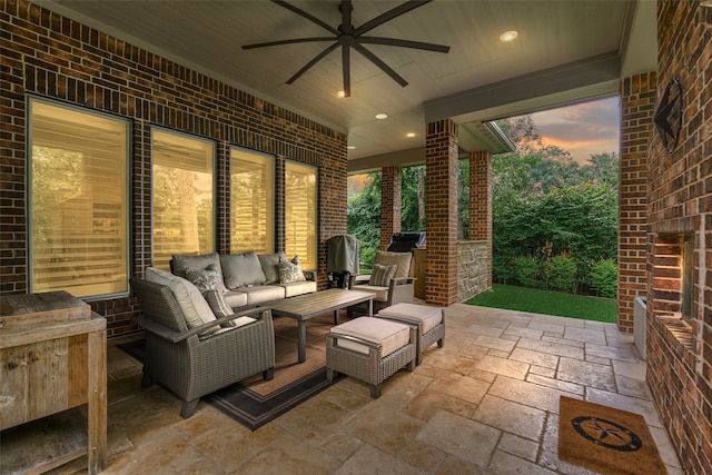 patio terrace at dusk featuring ceiling fan and an outdoor living space