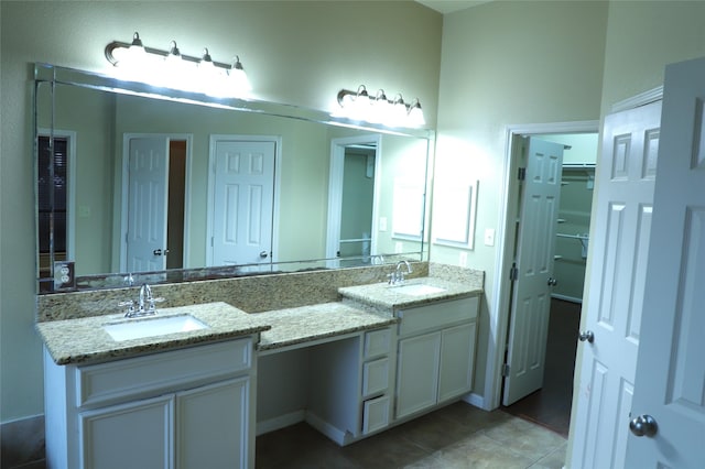 full bath with double vanity, a sink, and tile patterned floors