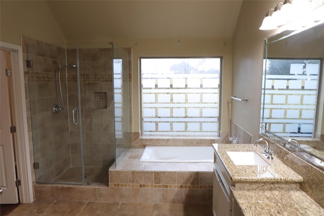 bathroom featuring lofted ceiling, vanity, a shower stall, and a wealth of natural light