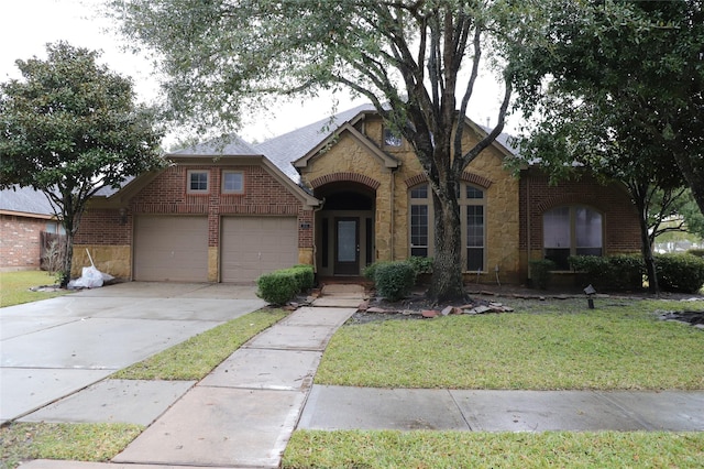 view of front of home with a garage, stone siding, brick siding, and driveway