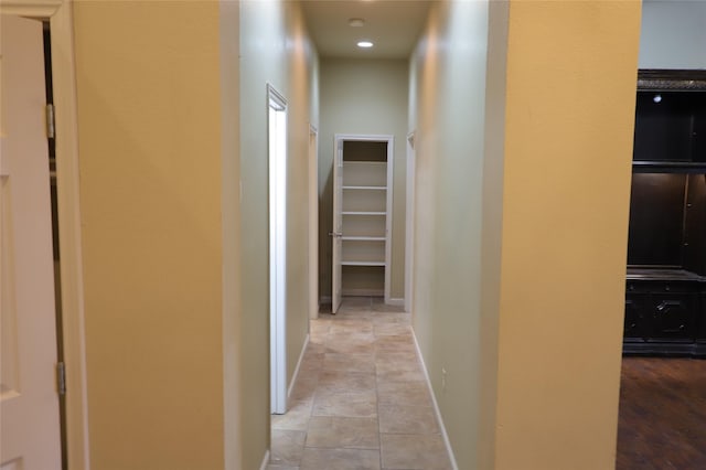 hallway featuring light tile patterned floors and baseboards